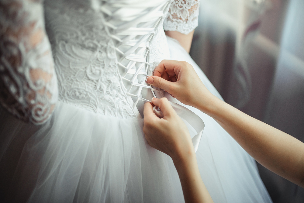 bridesmaid makes bow knot back brides wedding dress